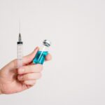 Person Holding Syringe and Vaccine Bottle